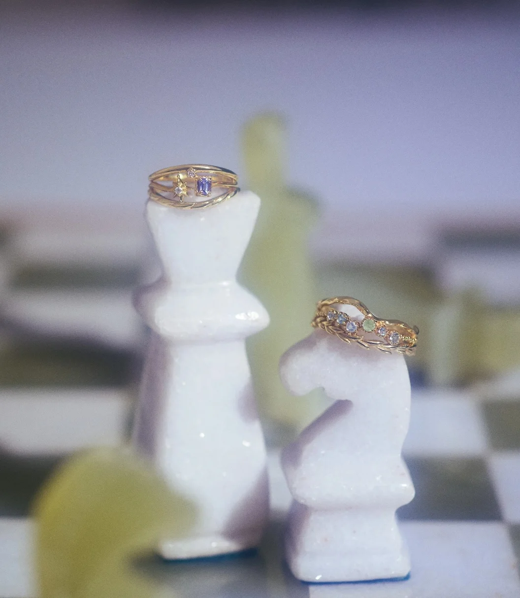 チェス盤上の白いチェス駒に置かれたゴールドのリング